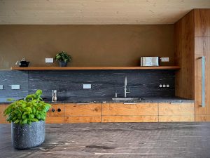 Küchenzeile und Kochinsel aus Massivholz mit Arbeitsplatte aus Stein
